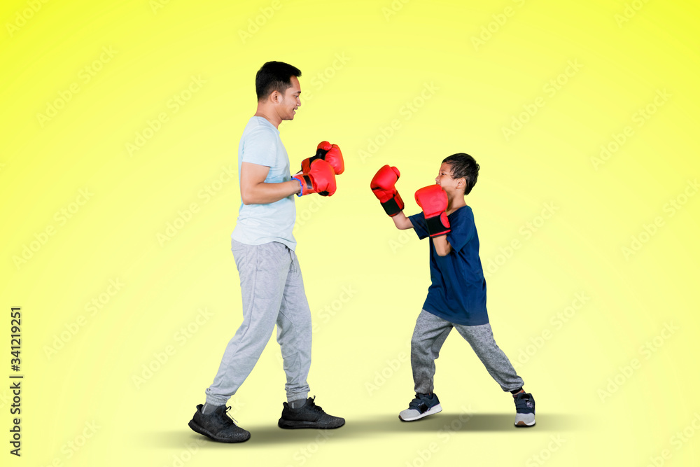 Young father and little boy doing boxing exercise