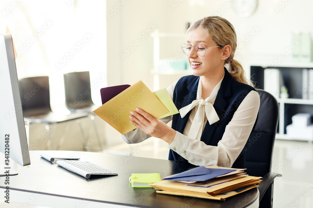 Young woman with letters in office Young woman with letters in office