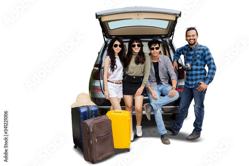 Young people standing behind the car with suitcase © Creativa Images