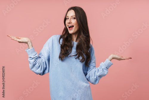 Image of attractive young woman smiling and throwing up her arms