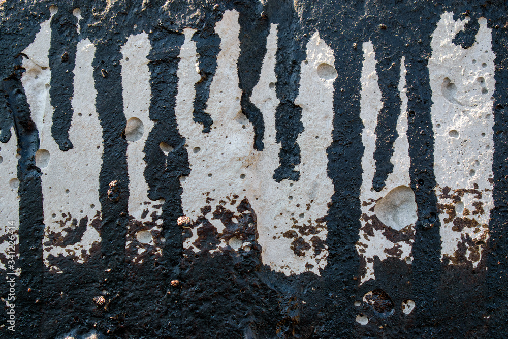 Concrete wall with black tar streams. Oily liquid spread. Concept of