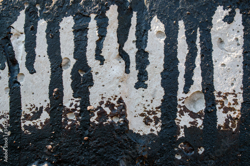 Concrete wall with black tar streams. Oily liquid spread. Concept of processing building structures from fungi, mold.