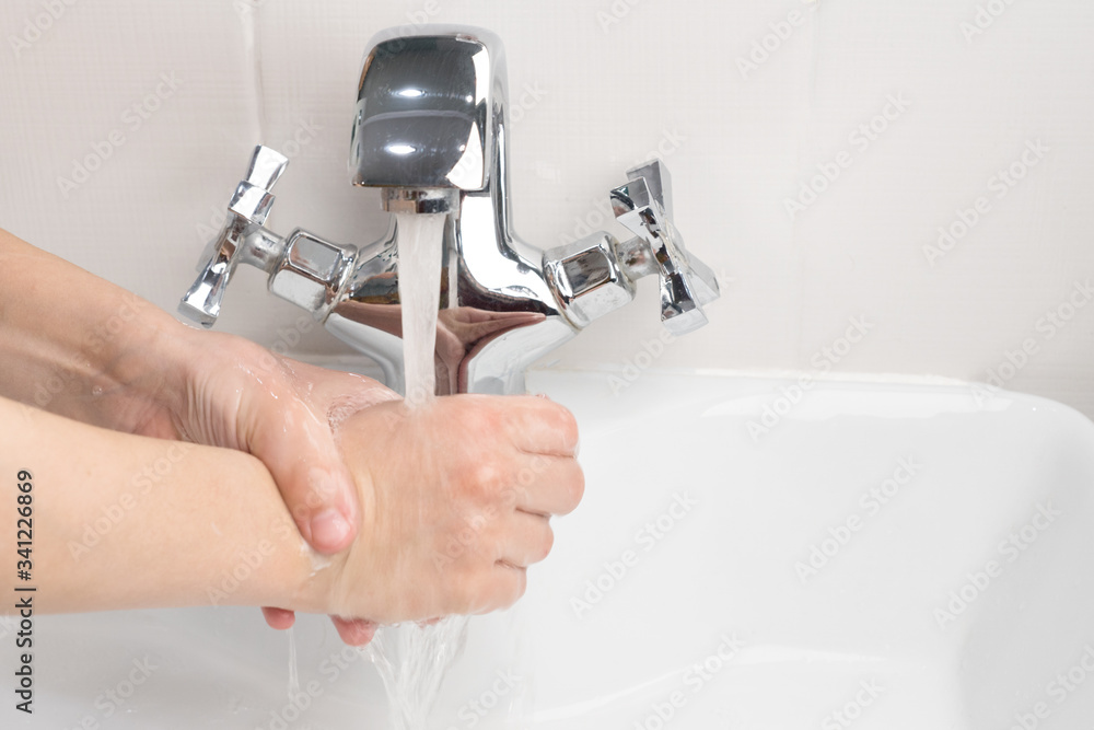 child washes his hands under the tap with pouring water in the bathroom, health care, hygiene protection from infection, virus, microbes, coronavirus child washes his hands under the tap with pouring water in the bathroom, health care, hygiene protection from infection, virus, microbes, coronavirus