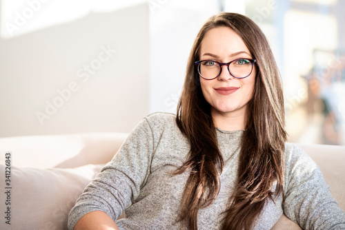 Smiling young woman relaxing on sofa at home