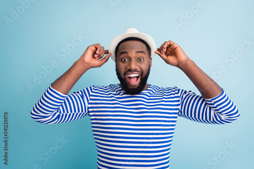 Photo of crazy dark skin guy traveler rest abroad spend free time sunny resort see low shopping center prices wear white sun cap striped sailor shirt isolated blue color background #341226876