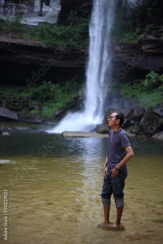 Man standing at Huai Luang Waterfall in Phu Chong   Na Yoi National Park Ubon Ratchathani  Thailand