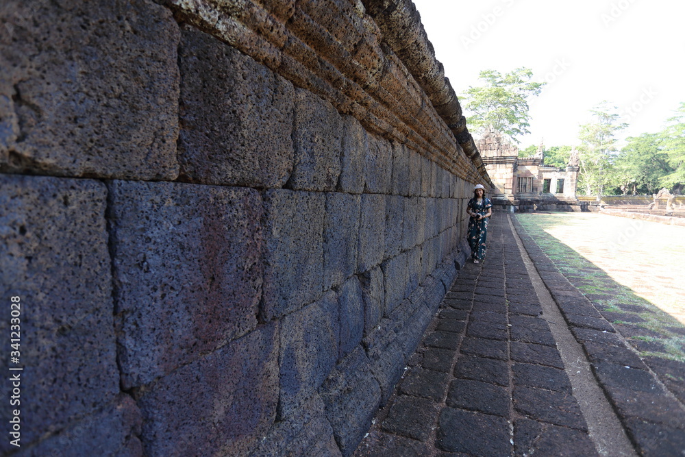 A woman by the wall of Prasat Mueang Tam (Mueang Tam castle) in Buriram, Thailand