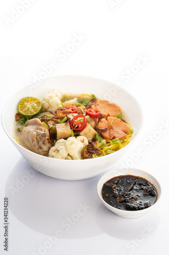 chicken noodle soup with hot sauce on white background