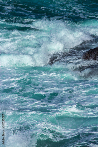 Aquatic background of sea surf waves splashing close up with clear blue green water and white foam