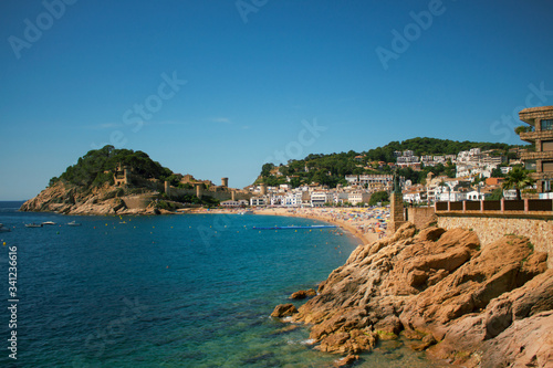 View of the tourist city in Spain with a beach, a fortress and stones.