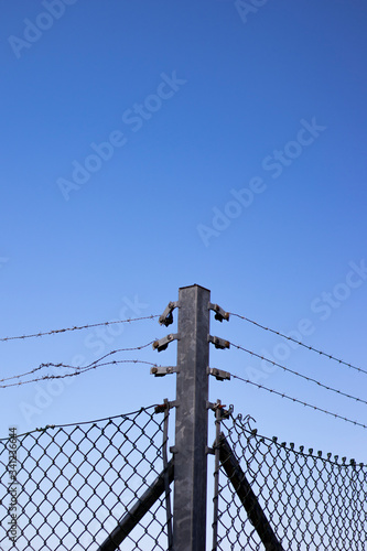 Hot dipped galvanised post and barbed wired mesh fence providing security to farmland in rural Hampshire