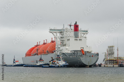 LNG TERMINAL AND GAS TANKER - A large ship maneuvers into the unloading quay
