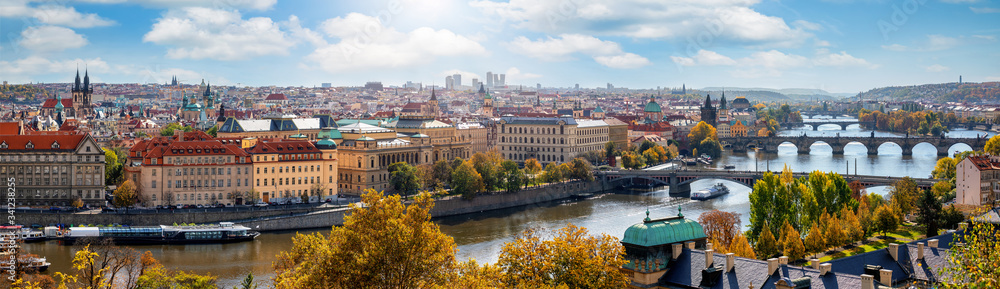 Fototapeta premium Weites Panorama der Stadtlandschaft von Prag, Tschechische Republik, an einem sonnigen Tag mit zahlreichen Sehenswürdigkeiten und der Karlsbrücke über die Moldau