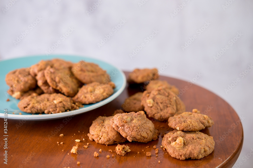 Delicious crunchy homemade chocolate cookies with walnut chunk on top of wooden table and white background. Delicious crunchy homemade chocolate cookies with walnut chunk on top of wooden table and white background.