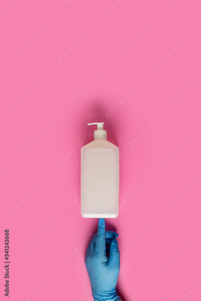 Doctor holds sanitizer gel in hands blue medical gloves on pink background. Pandemic corona virus, insurance, airborne diseases, SARS, grippe Doctor holds sanitizer gel in hands blue medical gloves on pink background. Pandemic corona virus, insurance, airborne diseases, SARS, grippe