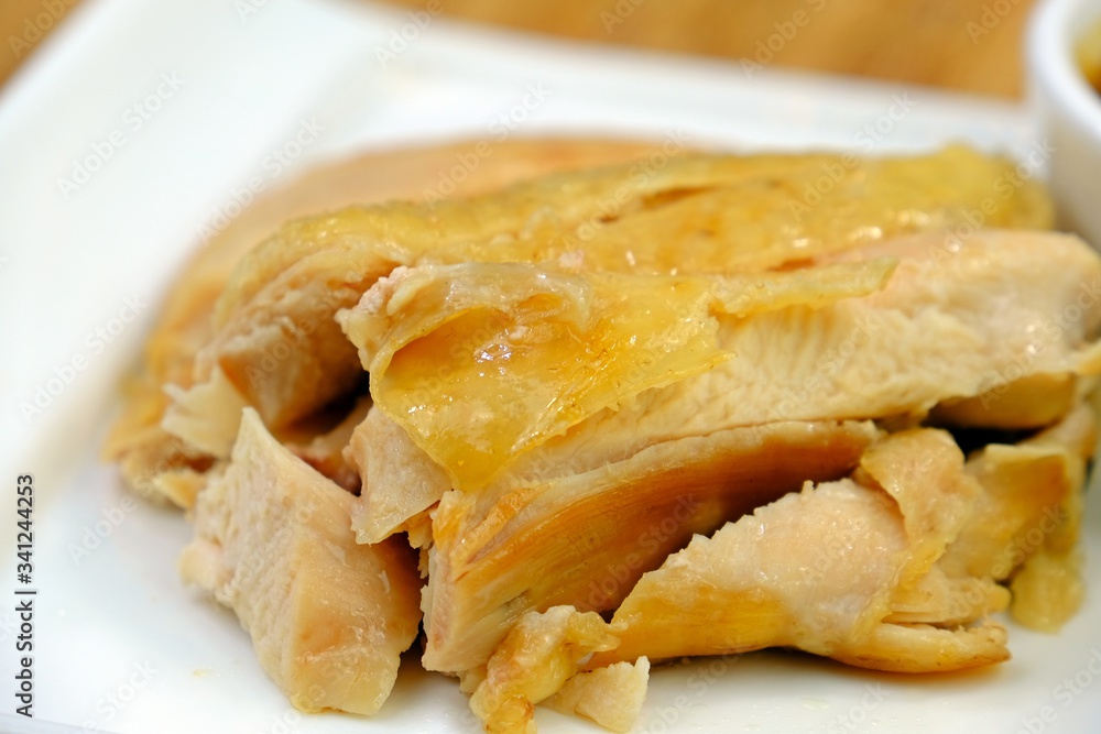 Sliced Hainan-style boiled chicken in white plate. Sliced Hainan-style boiled chicken in white plate.