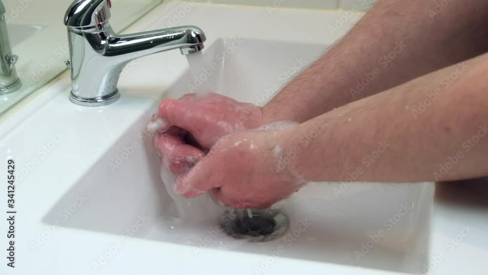 Man rinsing soap from hands under faucet after washing hands. Slow motion. Man rinsing soap from hands under faucet after washing hands. Slow motion.