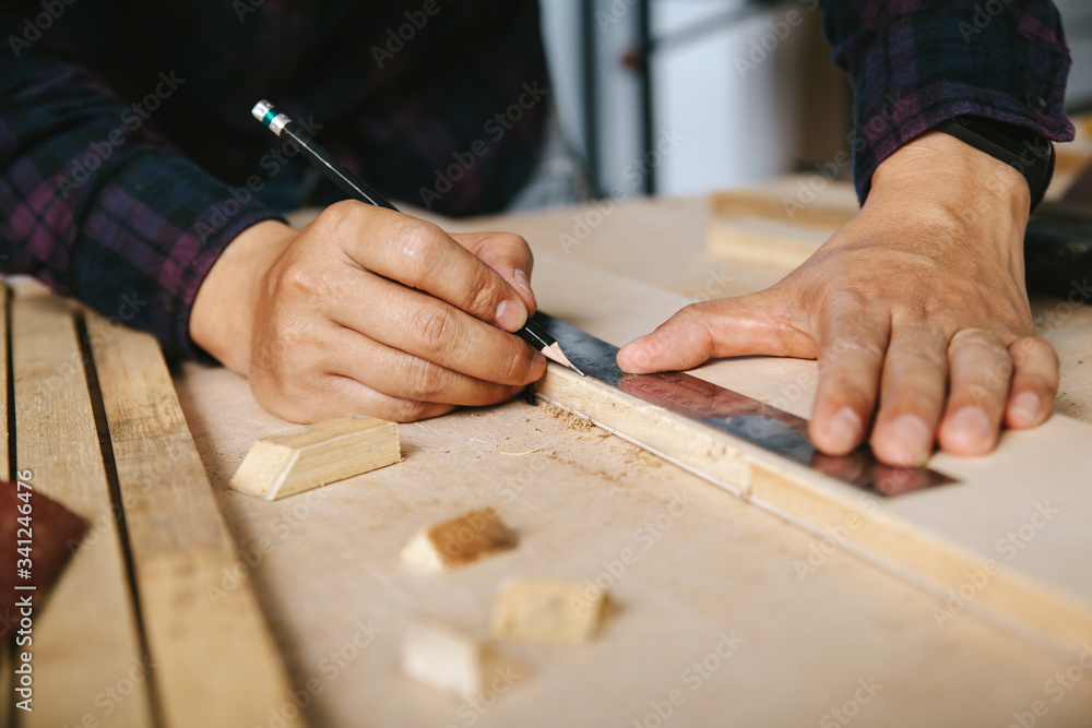 carpenter with a pencil and ruler mark on wooden board on table. Construction industry, housework do it yourself. carpenter with a pencil and ruler mark on wooden board on table. Construction industry, housework do it yourself.