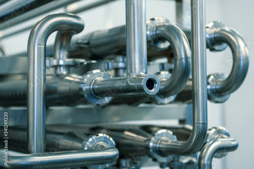 Industrial stainless steel piping connected by special nuts.