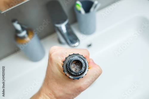 Rotary nozzle on the mixer to adjust the flow of water. White bathroom sink for washing hands