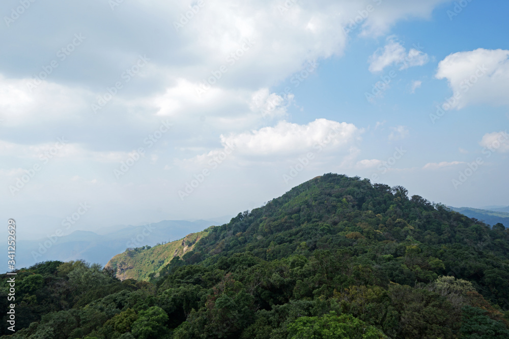 Natural landscape of green mountain range with cloudy blue sky Natural landscape of green mountain range with cloudy blue sky