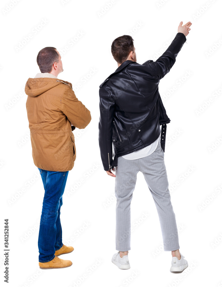 Back view of couple couple in winter jackets pointing. Back view of couple couple in winter jackets pointing.