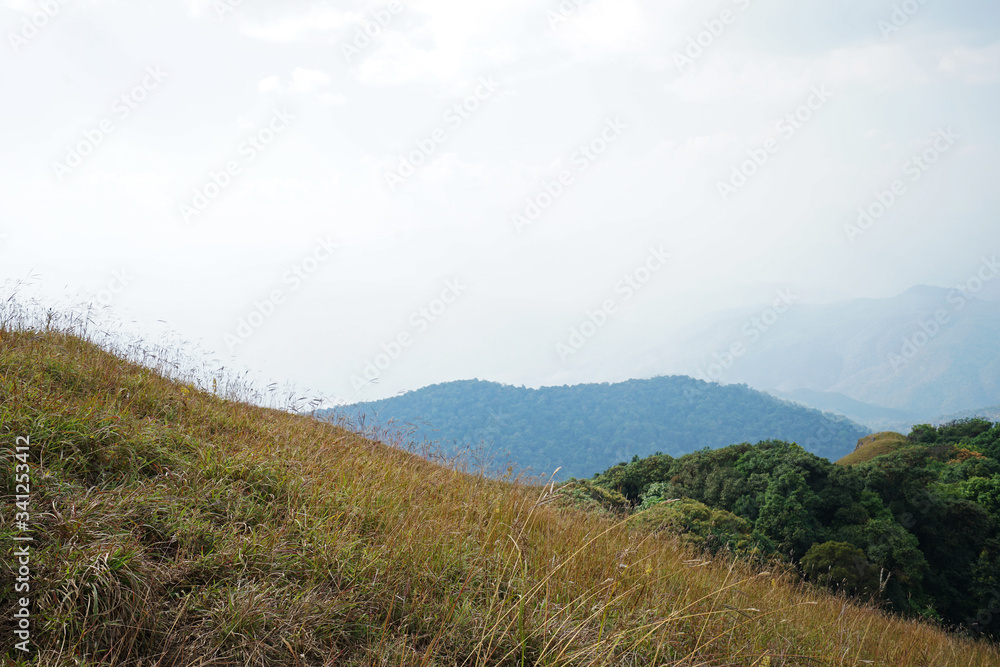 Natural landscape of green mountain range with cloudy blue sky Natural landscape of green mountain range with cloudy blue sky