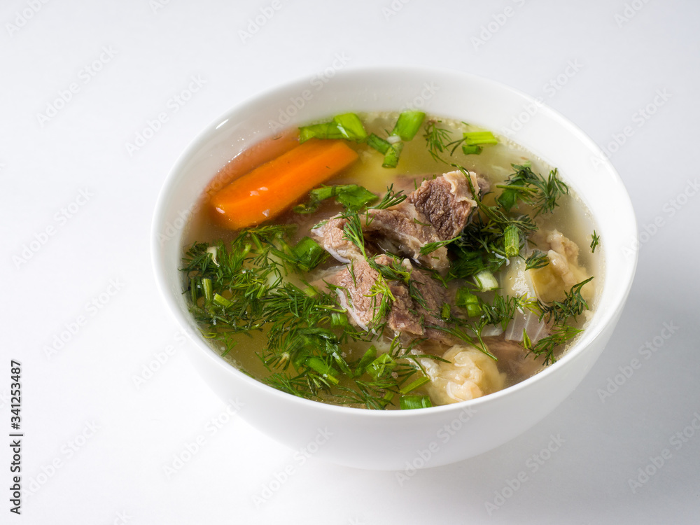 Shurpa soup. Beef with potatoes and carrots in a broth in a white bowl. Side view Shurpa soup. Beef with potatoes and carrots in a broth in a white bowl. Side view