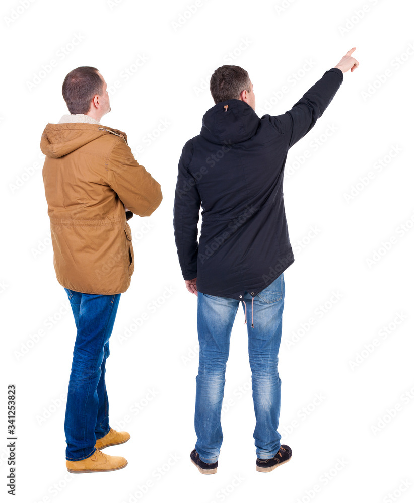 Back view of couple couple in winter jackets pointing. Back view of couple couple in winter jackets pointing.