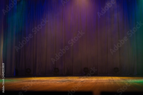 An empty stage of the theater, lit by spotlights and smoke before the performance