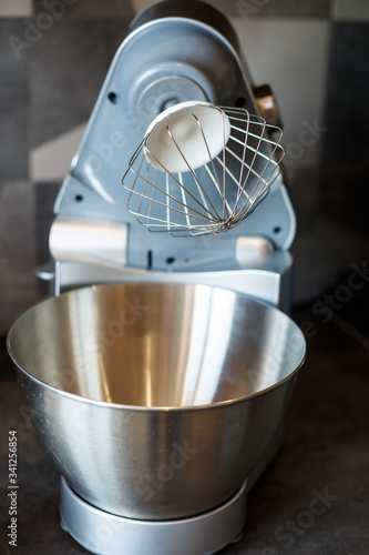 Beating eggs with sugar in a kitchen machine. Cream nozzle