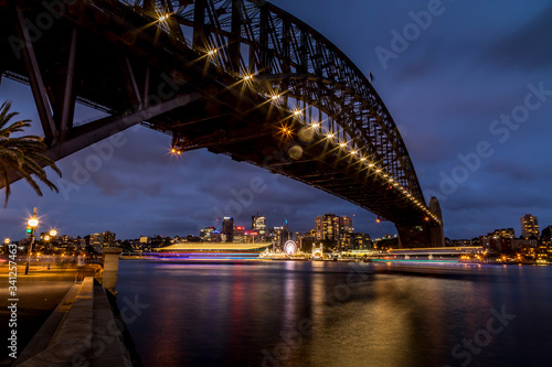 Sydney, Australia - 12th February 2020: A German photographer visiting Sydney in Australia, taking pictures of the Harbour Bridge at night with the Lunar park in the background.