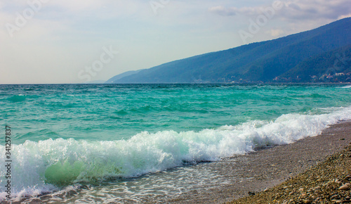 The promenade of the beach. Close-up photo of a wave of the Black Sea in Abkhazia