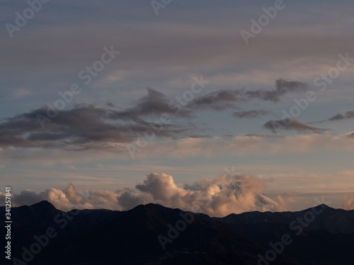 The tip of Mt. Fuji surrounded by clouds in the evening