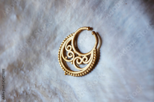 Brass metal nose decorative septum oriental boho jewelry on natural white shell background