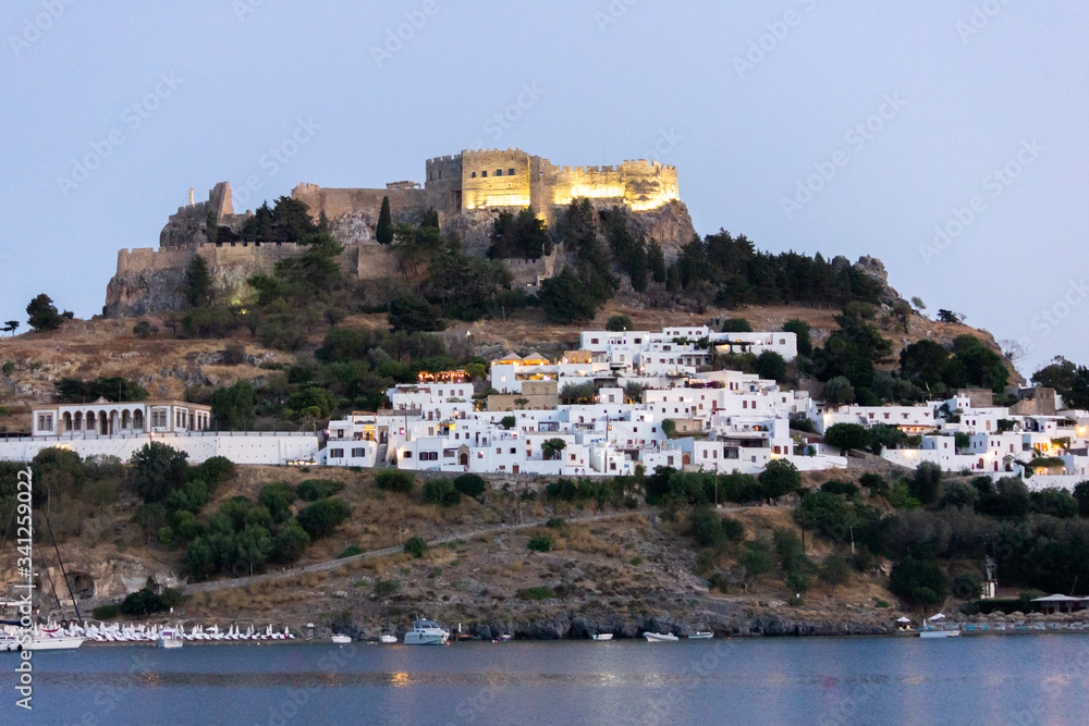Lindos Village in Rhodes, Greece. Panorama made from the sea at night.