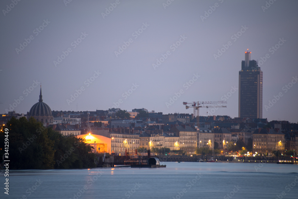 Fototapeta premium quai au bord d'un fleuve près de la ville de Nantes en France au lever du jour