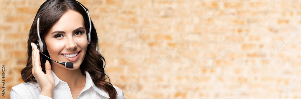 Portrait of happy smiling customer support female phone operator in headset, against loft style wall background. Consulting and assistance service call center. Portrait of happy smiling customer support female phone operator in headset, against loft style wall background. Consulting and assistance service call center.