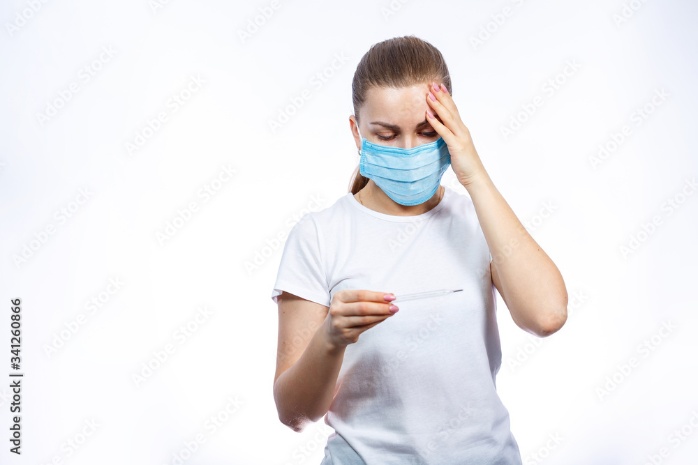 diseased woman in protective medical surgical mask with a thermometer in his hand treated against the virus. Isolated on white background diseased woman in protective medical surgical mask with a thermometer in his hand treated against the virus. Isolated on white background