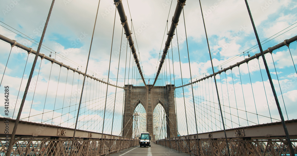 Fototapeta premium Police scooter car driving on Brooklyin bridge in New York during COVID-19. No people walking on usually crowded bridge during coronavirus pandemic