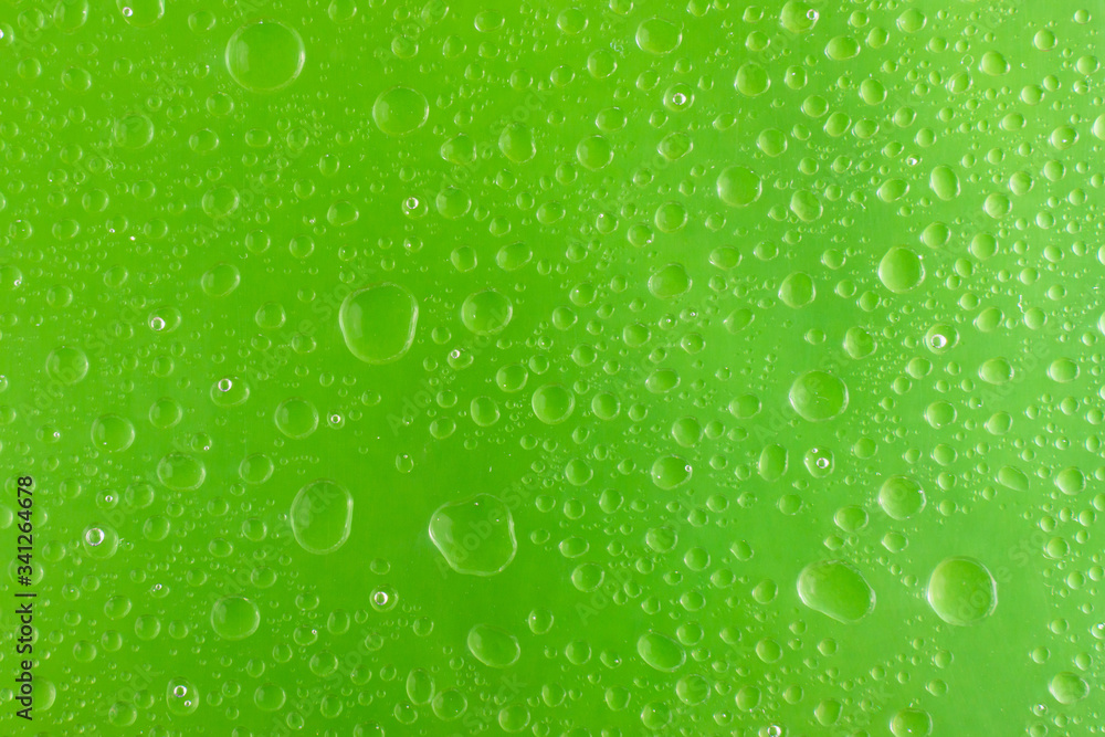 background for design of water drop close up on a green surface