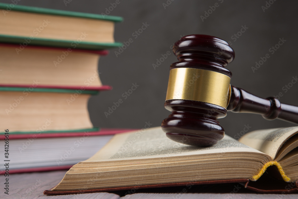 Wooden gavel and books on wooden table - law and auction concept