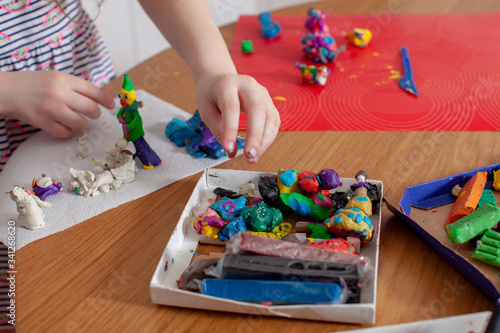7 years old baby craft with plasticine in the kitchen. Home interior. Home education.