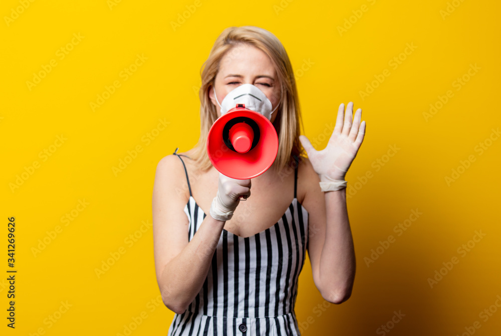 Obraz premium Blonde woman in face mask and gloves holds megaphone