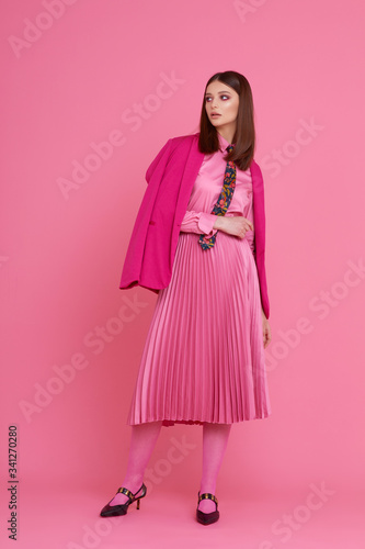 Fashion model in magenta jacket, pink skirt and shirt.