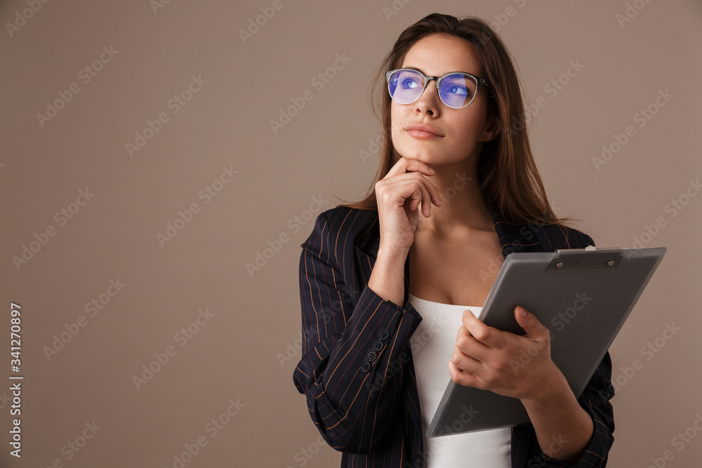 Photo of serious businesswoman in eyeglasses posing with clipboard