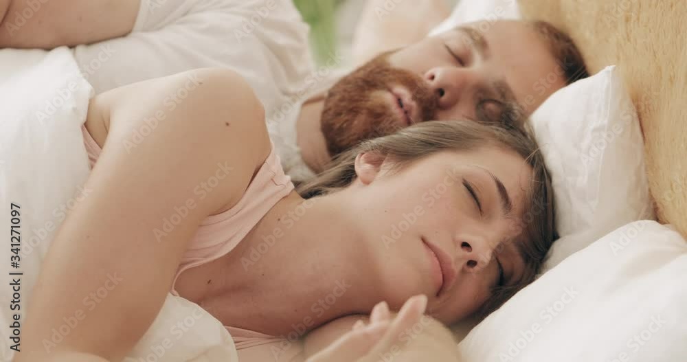 Portrait of young loving family cuddling in bed while sleeping in early morning. Handsome bearded man hugging woman while lying on bed and dreaming. Concept of relationship. Portrait of young loving family cuddling in bed while sleeping in early morning. Handsome bearded man hugging woman while lying on bed and dreaming. Concept of relationship.