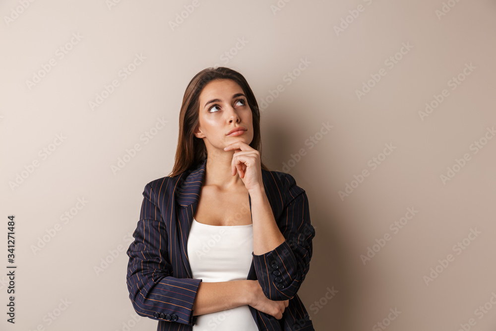 Photo of young businesswoman in formal suit thinking and looking upward Photo of young businesswoman in formal suit thinking and looking upward