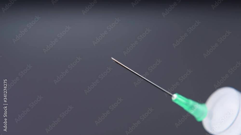 Medicine leaking from a syringe drop by drop. Medicine leaking from a syringe drop by drop.