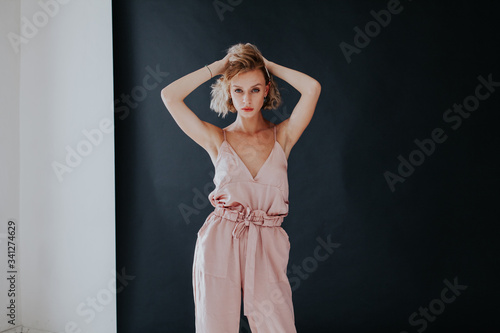 Portrait of a beautiful fashionable woman in a pink jumpsuit